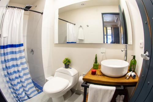 La salle de bains est pourvue de toilettes blanches et d'un lavabo. dans l'établissement Casa Lorenza Hotel, à Carthagène des Indes