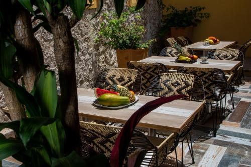 - une table et des chaises avec une assiette de fruits dans l'établissement Casa Lorenza Hotel, à Carthagène des Indes