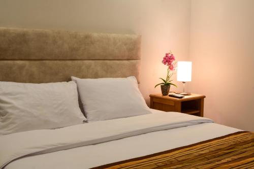 a bedroom with a bed and a table with a lamp at Casa Lorenza Hotel in Cartagena de Indias