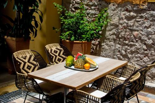 a wooden table with a plate of fruit on it at Casa Lorenza Hotel in Cartagena de Indias