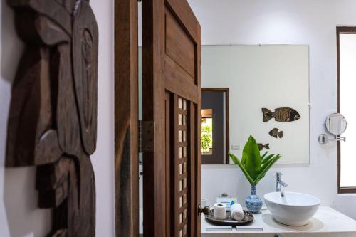 y baño con lavabo y espejo. en Mahogany Resort & Spa, en El Nido