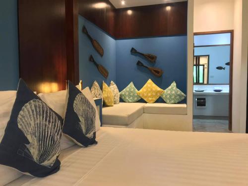 Un dormitorio con una cama grande con almohadas. en Mahogany Resort & Spa, en El Nido
