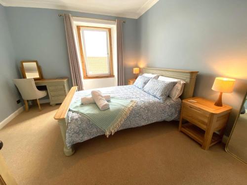 a bedroom with a bed with a table and a window at Coastal Retreat in Fife