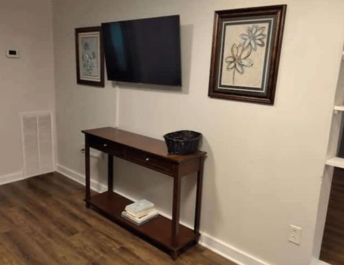 sala de estar con mesa y TV en la pared en 3 Bed 3 Bath House, Conveniently close to everything, Smart Tvs in all rooms whole house to yourself, en New Bern