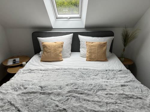 a bed with white sheets and pillows and a window at Connect 9.1 in Dorum-Neufeld