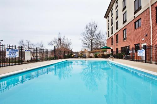 a large blue swimming pool next to a building at Holiday Inn Express & Suites Greenville-Downtown, an IHG Hotel in Greenville