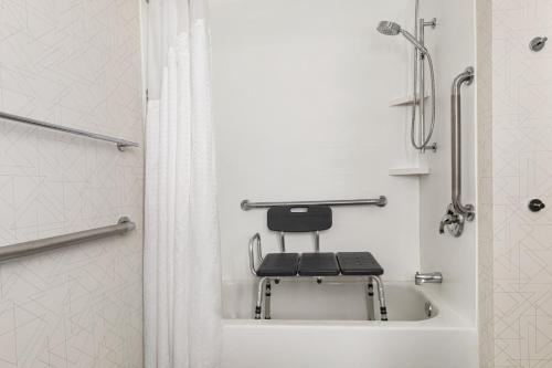 a bathroom with a chair in a shower at Holiday Inn Express & Suites Greenville-Downtown by IHG in Greenville