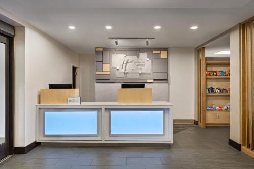 an office with a reception counter with blue windows at Holiday Inn Express & Suites Greenville-Downtown by IHG in Greenville