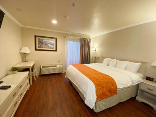 a hotel room with a large bed and a desk at Monarch Valley Inn Marina at Monterey Bay in Marina