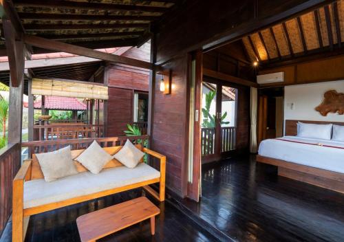 a bedroom with a bed and a couch in a room at Amanuba Ersadeva Resort in Pulukan