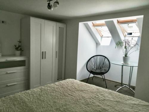 una camera da letto con un letto, una sedia e un tavolo di Lovely loft a Cluj-Napoca