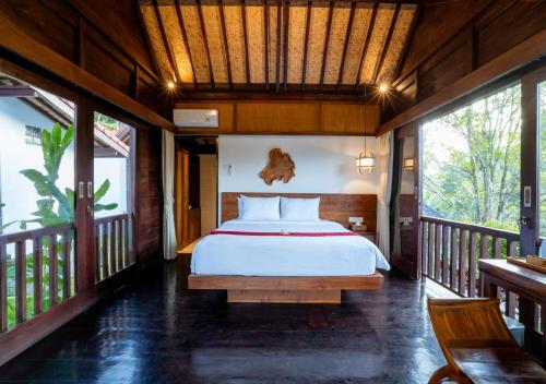a bedroom with a bed on a balcony at Amanuba Ersadeva Resort in Pulukan
