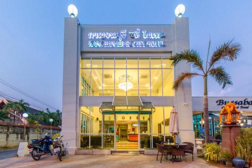 北碧的住宿－Kanchanaburi City Hotel - SHA Extra Plus，停在前面的一座带摩托车的建筑