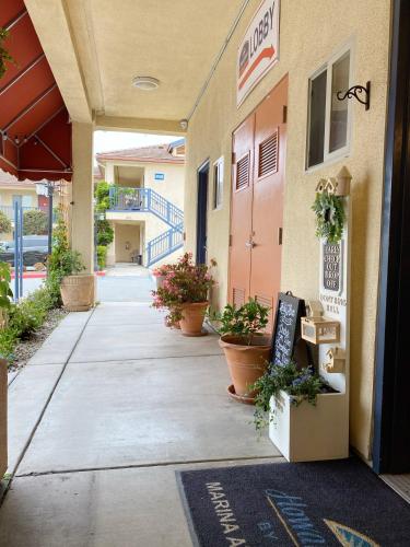 a walkway outside of a building with potted plants at Monarch Valley Inn Marina at Monterey Bay in Marina