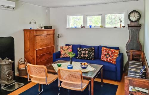 YngsjöにあるNice Home In Yngsj With 2 Bedroomsのリビングルーム(青いソファ、テーブル付)