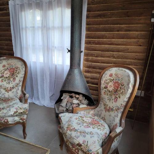 two chairs and a fireplace in a room at ENTRE VIÑAS in Ciudad Lujan de Cuyo