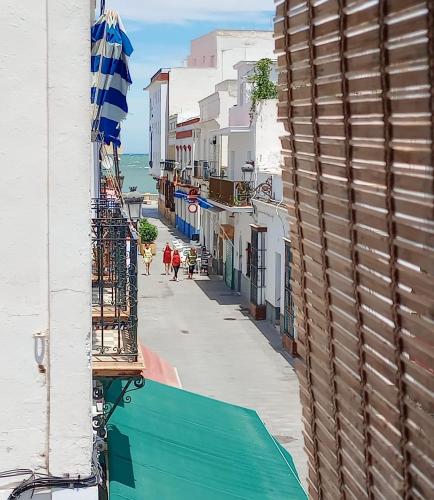 uma vista para uma rua com um edifício e o oceano em Apartamento El Colmao em Chipiona