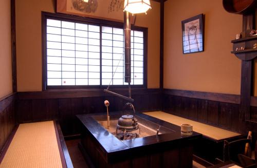 a kitchen with a stove in the middle of a room at Kurokawa Onsen Yama no Yado Shinmeikan in Minamioguni