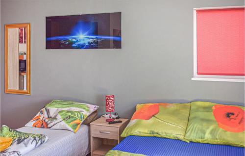 a bedroom with two beds and a picture on the wall at Beautiful Apartment In Darlwko With Wifi in Darłówko
