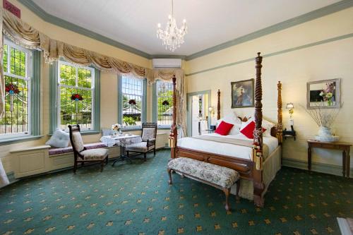 um quarto com uma cama, uma mesa e cadeiras em The Old Bank Gladstone Licensed Restaurant & Boutique Accommodation em Hat Head