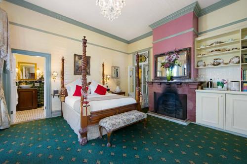 um quarto com uma cama e uma lareira em The Old Bank Gladstone Licensed Restaurant & Boutique Accommodation em Hat Head