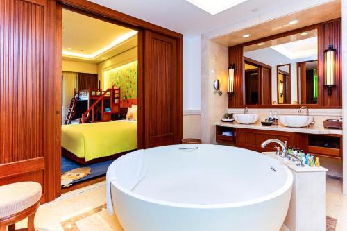 a bathroom with a tub and a bedroom at InterContinental Xishuangbanna Resort by IHG in Jinghong