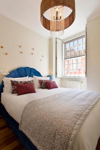 a bedroom with a large bed and a chandelier at BOUTIQUE Rentals- DOURO Ribeira historical center with parking in Porto