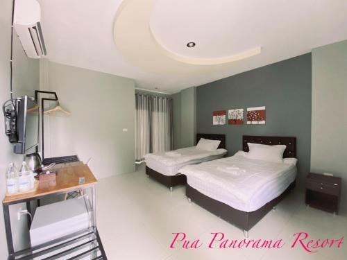 a bedroom with two beds and a desk and a television at Pua Panorama Resort in Nan