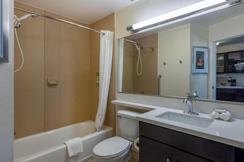 a bathroom with a sink and a tub and a toilet at Candlewood Suites Springfield South, an IHG Hotel in Springfield