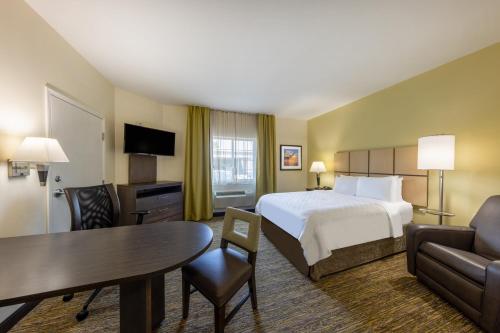 a hotel room with a bed and a table at Candlewood Suites Springfield-Medical District by IHG in Springfield