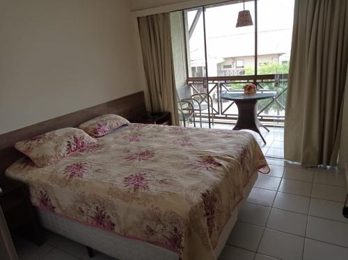 een slaapkamer met een bed en een balkon met een tafel bij Flat Monte Castelo - Gravatá in Sairé