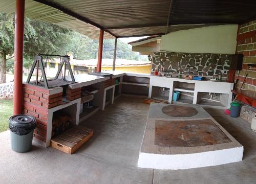 a patio with a grill and a brick wall at Finca Marix, Villa del Carbón in Villa del Carbón