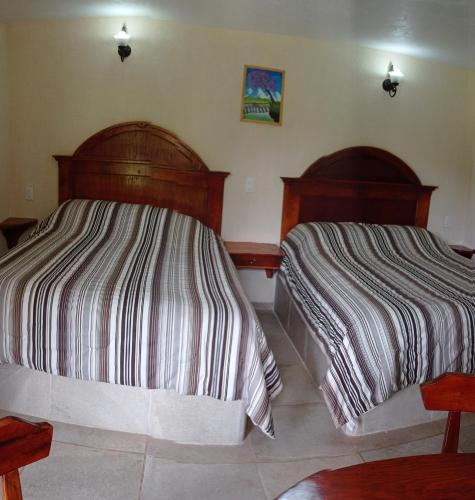two beds sitting next to each other in a bedroom at Finca Marix, Villa del Carbón in Villa del Carbón