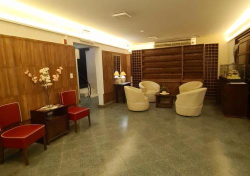 亞松森的住宿－Hotel Hassler，一间设有白色椅子的等候室和一个沙龙
