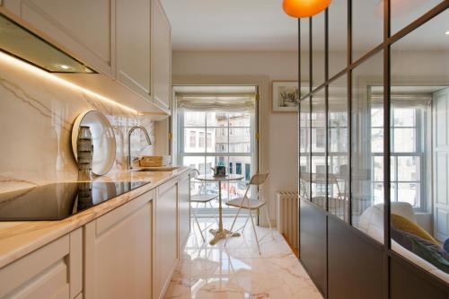 een keuken met witte kasten en een aanrecht bij BOUTIQUE Rentals-Isabella Ribeira Apt great views in Porto