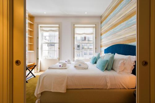 een slaapkamer met een groot bed en handdoeken bij BOUTIQUE Rentals-Isabella Ribeira Apt great views in Porto