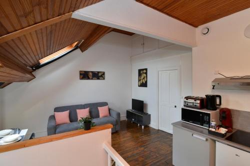 a living room with a couch and a kitchen at Home Group in Saint-Quentin