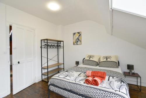 a bedroom with a bed with orange and black pillows at Home Group in Saint-Quentin