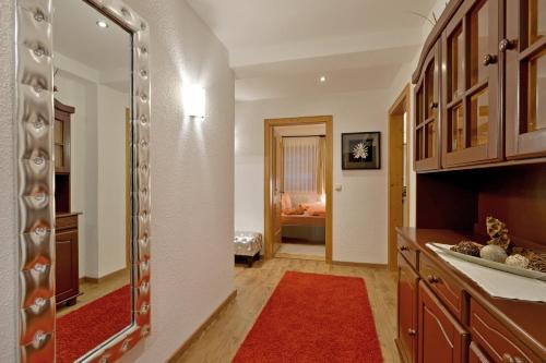 cocina con espejo y alfombra roja en Ferienwohnung Fankhauser, en Mayrhofen