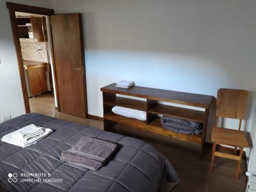 a bedroom with a bed and a table and a chair at LodeJimmy in El Chalten