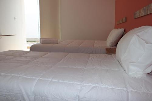 a bedroom with two beds and a window at La Estancia Hotel Ica in Ica