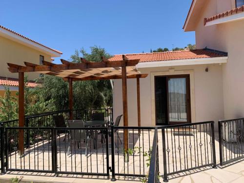 a patio with a wooden pergola in front of a house at Magnolia CAPTAINS HOUSE with A POOL in Limassol