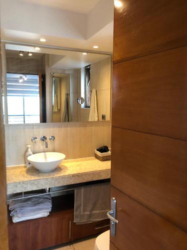 uma casa de banho com um lavatório e um espelho em Departamento en el Corazon de Providencia em Santiago