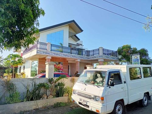 een wit busje geparkeerd voor een huis bij Marino Transient House in Alaminos