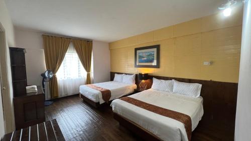 a hotel room with two beds and a television at Condo D'Savoy @ Famosa, Malacca in Melaka