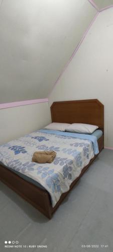 a bedroom with a bed with a wooden head board at PISAAN FARMSTAY Bed & Breakfast in Ranau