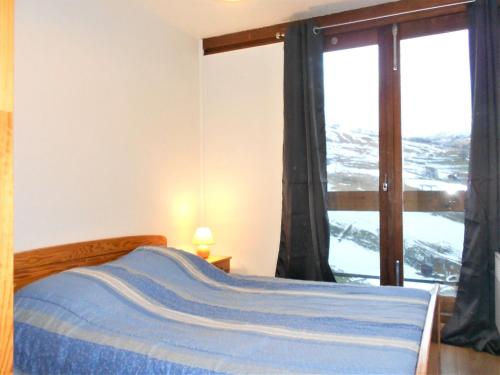 une chambre avec un lit et une grande fenêtre dans l'établissement Appartement Pied des Pistes avec Balcon et Piscine Chauffée - FR-1-267-177, à Villarembert