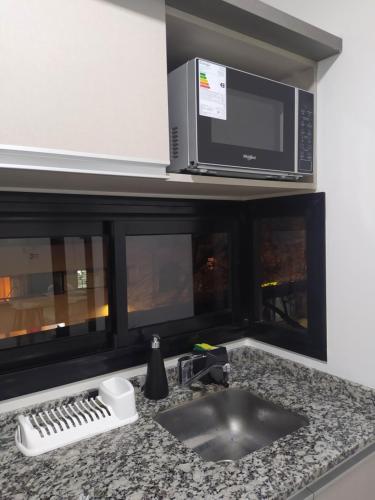 eine Küchentheke mit einer Spüle und einer Mikrowelle in der Unterkunft Brasil flats-Nueva Cordoba in Cordoba