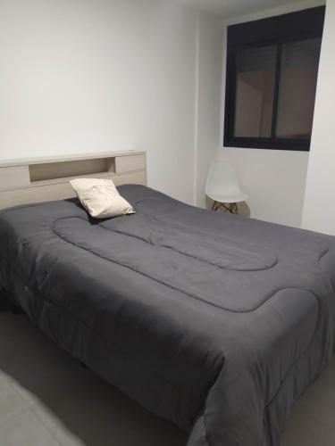ein großes Bett in einem weißen Zimmer mit einem Kissen darauf in der Unterkunft Brasil flats-Nueva Cordoba in Cordoba