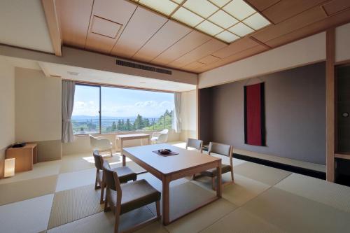 a dining room with a table and chairs and a large window at Onyado Toho in Aizuwakamatsu